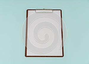 Clip board and paper on blue background .