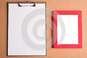 Clipboard and blank frame on wooden table