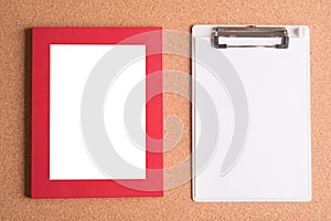 Clipboard and blank frame on wooden table