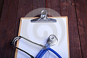 Clipboard with blue stethoscope on white background. Health diagnostic concept