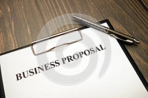 Clipboard with business proposal and pen on desk