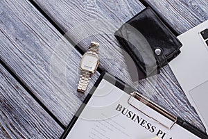 Clipboard with businessplan and luxury clock watch.