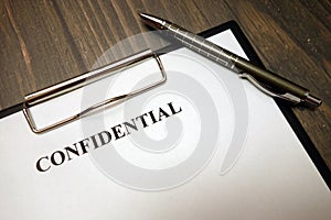 Clipboard with confidential document and pen on desk