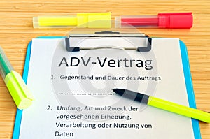 Clipboard with a contract and inscription in german ADV-Vertrag in english ADV contract and subject matter and duration of the con