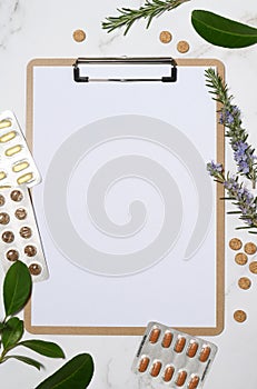 Clipboard with emty blank and organic capsules and pills