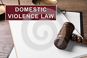 Clipboard and gavel on table. Domestic violence law concept