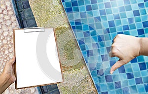 Clipboard in girl hand over Damage swimming pool edge from acid water