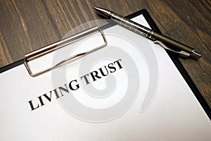 Clipboard with living trust and pen on desk