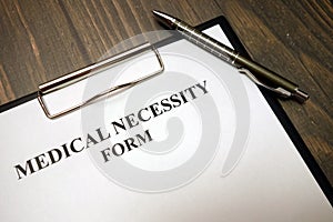 Clipboard with medical necessity form and pen on desk