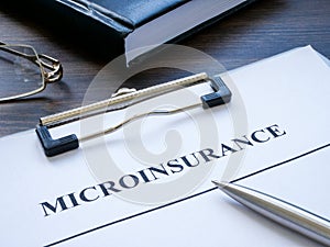Clipboard with microinsurance application and a notepad. photo