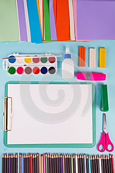 Clipboard and office or school supplies over blue background, flat lay. Back to school