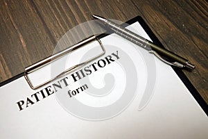 Clipboard with patient history form and pen on desk