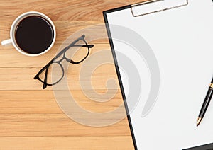 Clipboard with pen ,eyeglasses and coffee cup on vintage brown w