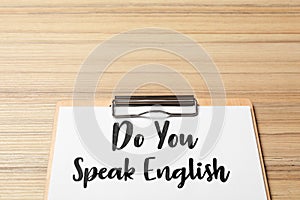 Clipboard with question Do You Speak English on wooden table, closeup. Space for text