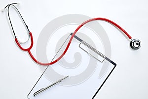 clipboard with red stethoscope and pen