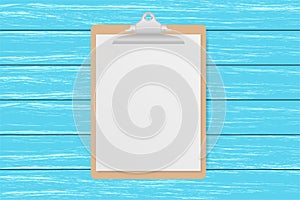 Clipboard with white sheet on old blue wooden background