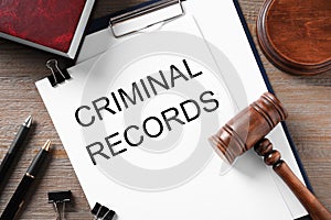 Clipboard with words CRIMINAL RECORD and gavel on table, flat lay