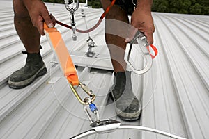 Clipping industrial hook connected with fall arrest shock absorbing safety lanyard device into horizontal lifeline