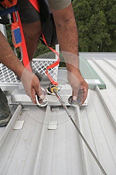 Clipping industrial Karabiner connected with fall arrest shock absorbing safety lanyard device into horizontal lifeline