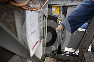 Clipping safety carabiner attached lanyard on anchor point of building maintenance unit body prior entry