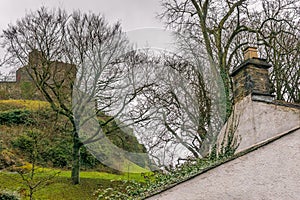 Clitheroe castle on a winters day, on a hill with house roof and chimney.