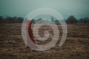 Cloaked person in a cold moorland