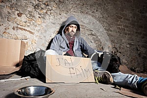 Clochard with dog and cardboard sign on the street