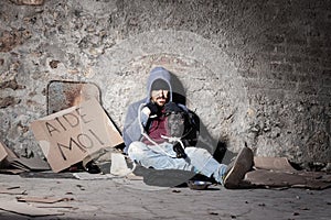 Clochard man with his dog sitting on the street