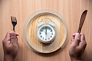 The clock is at 12:00 noon for lunch in a wooden dish.