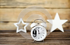 Clock at 7 O`clock in the morning with vintage style alarm clock and toys as stars on a wooden table