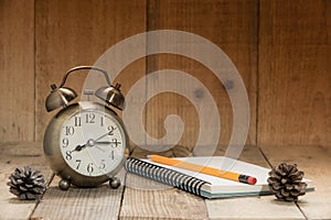 Clock Alarm,Pencil,Note book, on Wooden Floor