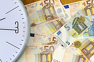 Clock and banknotes of Euro. Concept time is money. View from above. Business, finance.