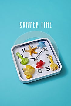 Clock, beach toys and text summer time