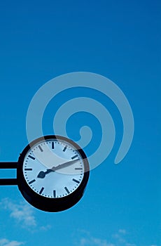 Clock on blue sky background