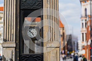 Clock on blurred urban street in