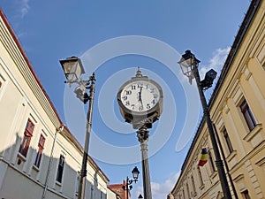 Clock and buildings on a street in Baia Mare city, Romania