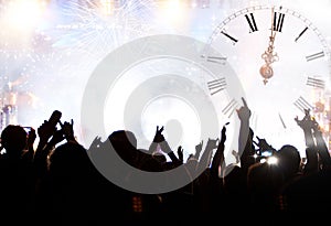 Clock close to midnight, fireworks and crowd waiting for New yea