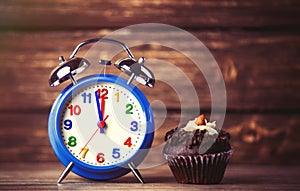 Clock and cupcake on the table
