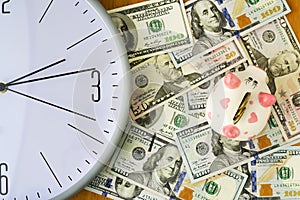 Clock, dollars and piggy bank. Concept time is money. View from above. Business, finance.