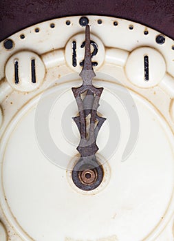 Clock face of old clock with worn numbers and arrows