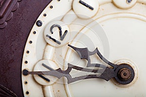 Clock face of old clock with worn numbers and arrows