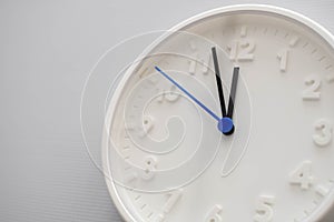 Clock face showing twelve o`clock with white background. White round wall clock. Twelve o`clock. Midday or midnight. 12 a.m. or
