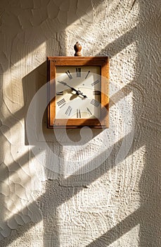 a clock is facing down onto a white wall, in the style of luminous shadows