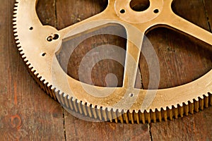 Clock gear, gold and wheel cog on a wood table with golden machinery and gears. Metal, closeup and steel with machine