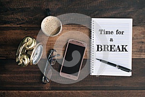 Clock, glasses, phone, coffee, mug and notebook with TIME FOR A BREAK word