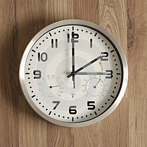 A clock, the gray hand points to three o\'clock, the black one to two o\'clock. Symbol of the time change.