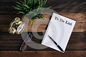 Clock, green plant, glasses and notebook with TO DO LIST word