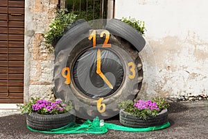 Clock made with car tires and flowers on \