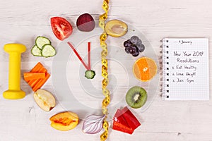 Clock made of fruits and vegetables, dumbbell and centimeter, new year resolutions of healthy lifestyles