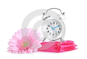 Clock, menstrual pads and flower on white background. Gynecology